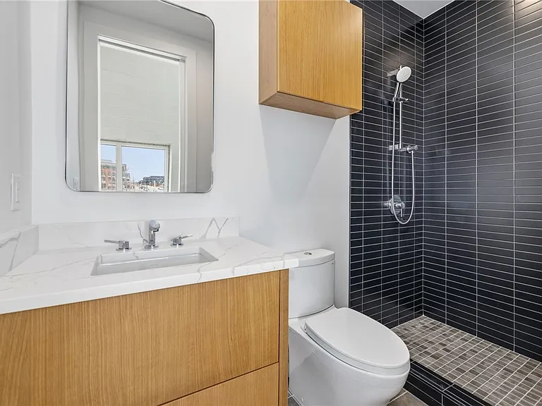 Bathroom with white oak vanity and dark tile shower