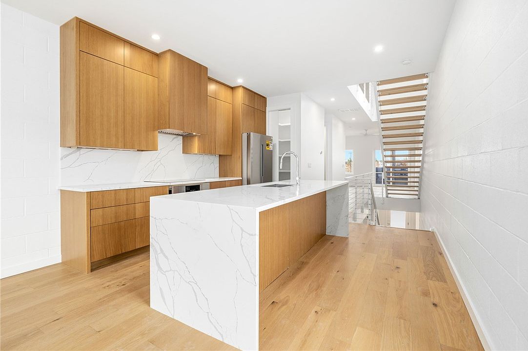 Chef's kitchen with white oak cabinetry and quartz waterfall island